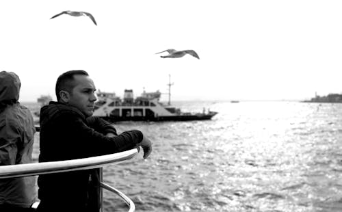 Birds Flying over Man Sailing in Black and White