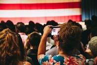 在繁忙的室内集会上，人群拍摄美国国旗的照片，体现了团结和爱国主义