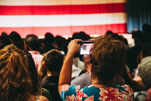 在繁忙的室内集会上，人群拍摄美国国旗的照片，体现了团结和爱国主义