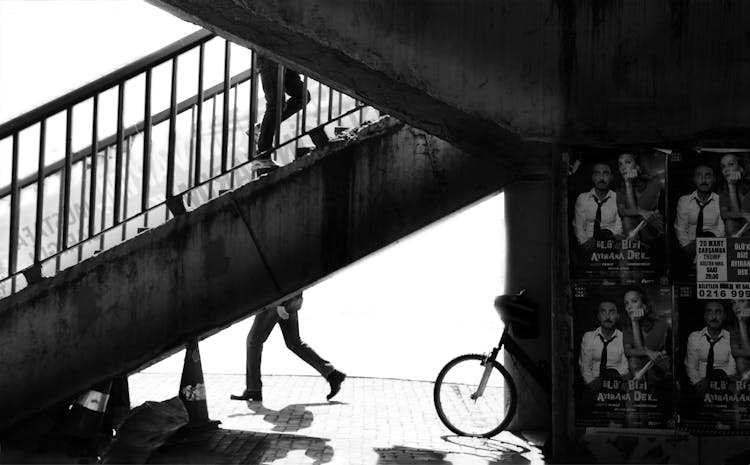 Black And White Photo Of A Staircase And Posters On A Wall