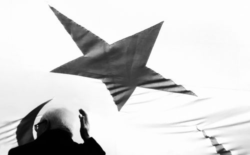 Free Artistic black and white photo of a man under a star on the Turkish flag, symbolizing patriotism. Stock Photo
