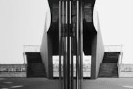 一张黑白图像展示了带有反光表面的现代楼梯，突出了建筑的对称性