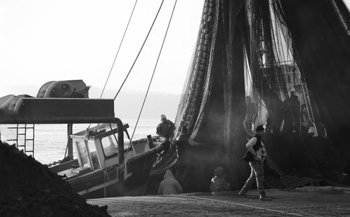 Free Fishermen managing large nets on a traditional sailing ship in grayscale. Stock Photo
