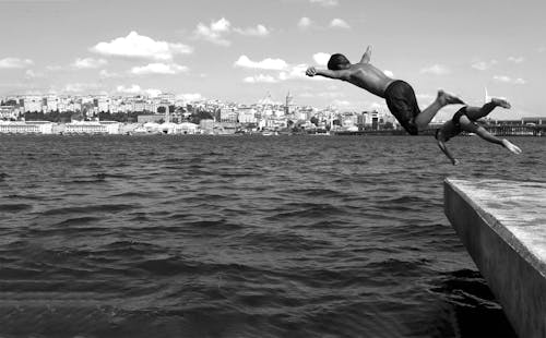 Black and White Photo of Kids Diving in the Sea