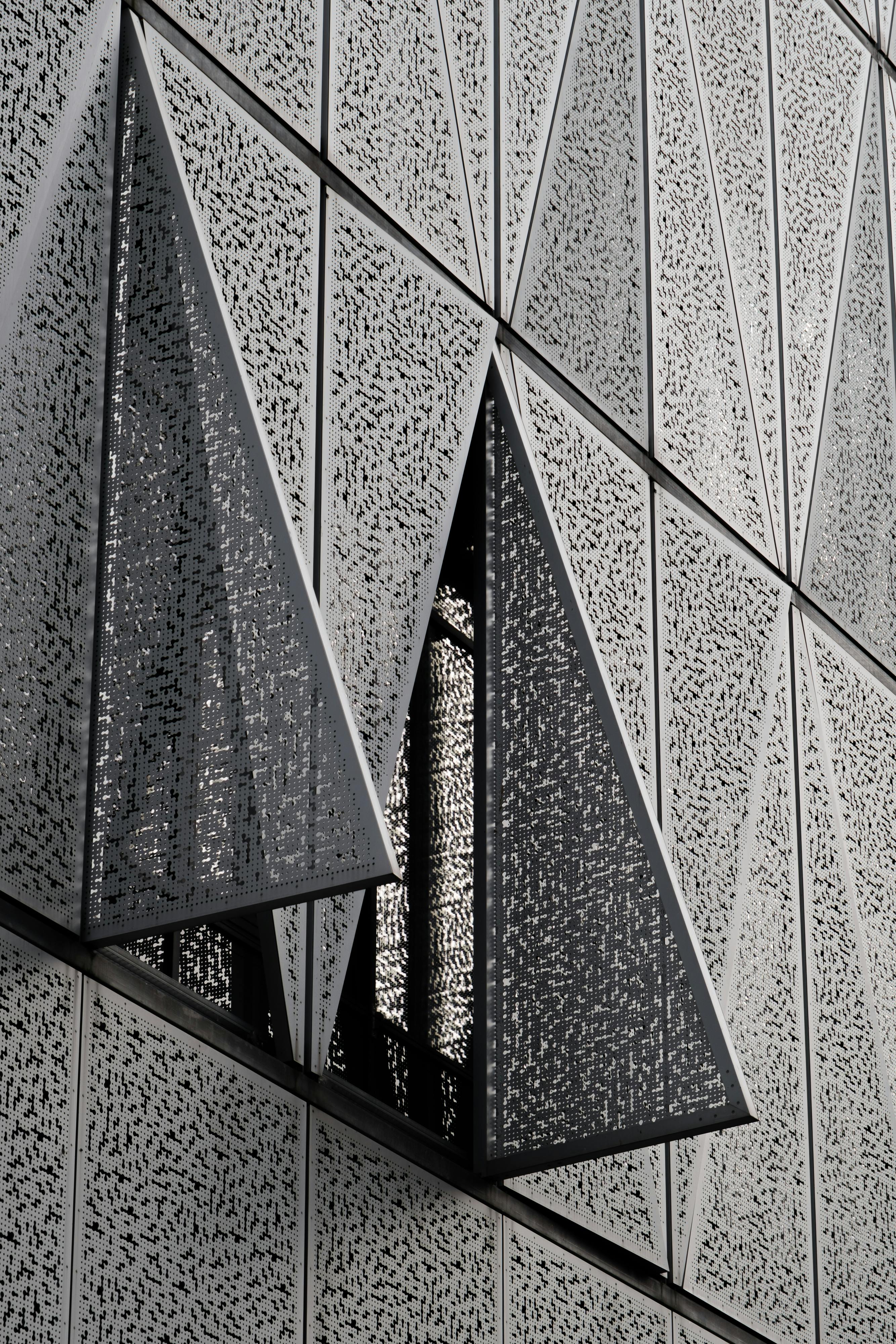 Close-up of a modern building facade featuring geometric patterns and triangles.