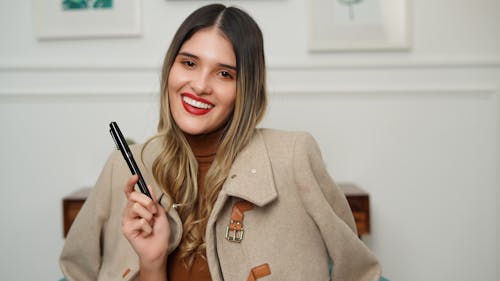 A Woman in Brown Coat Holding a Black Pen