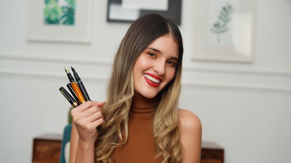 Smiling woman with pens