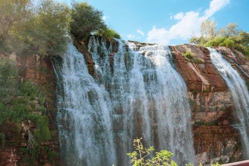 Waterfalls on Brown Rock Formation under Blue Sky