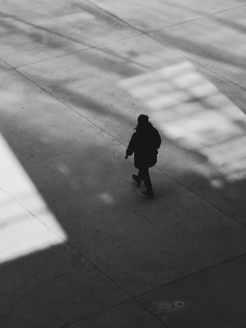 A Person Walking in Grayscale Photography