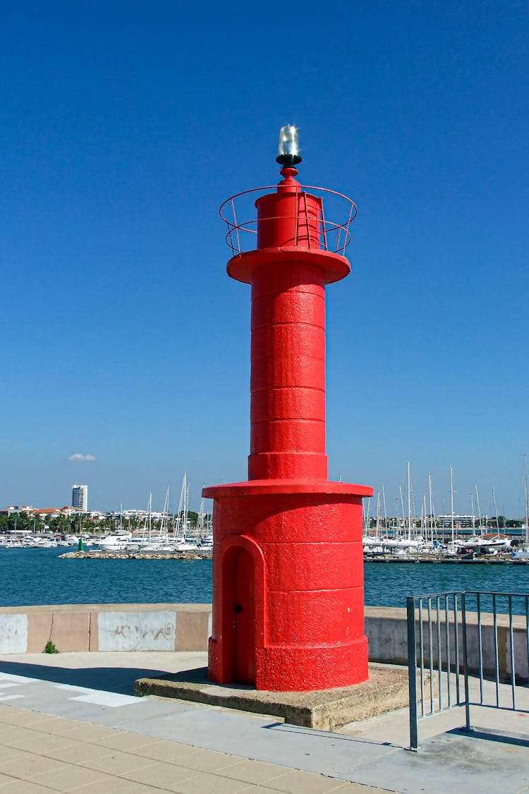 Red Concrete Lighthouse Under Blue Sky