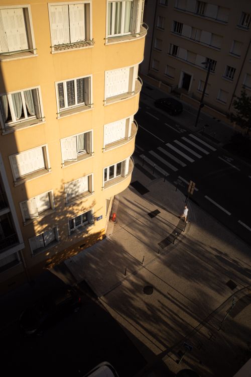 Free Overhead view of a modern apartment building in Lyon, France with a street scene below at sunset. Stock Photo