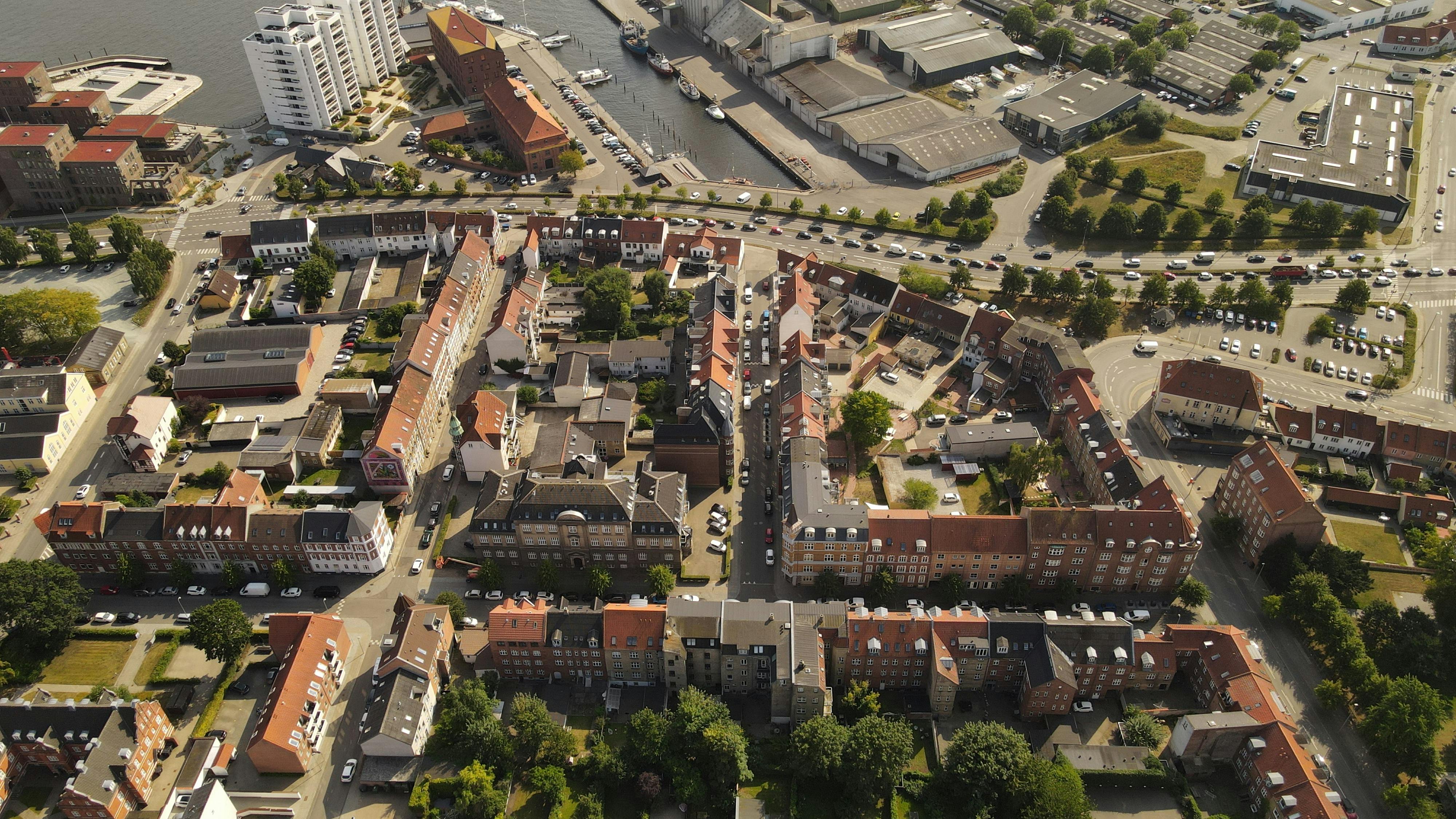 Aerial view of Horsens, Denmark showcasing buildings, streets, and waterways in summer.