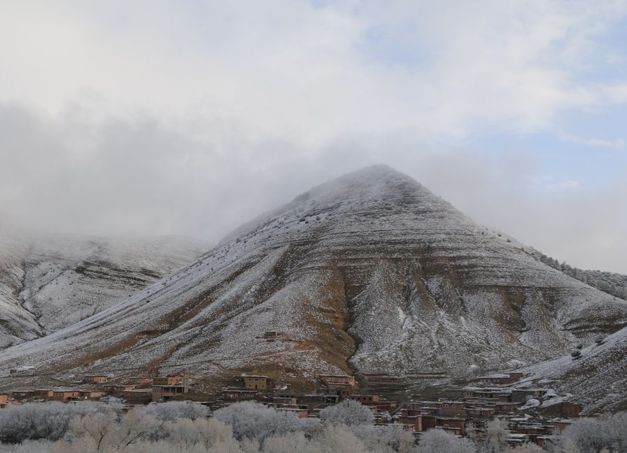A stunning winter landscape of snow-covered mountains and village in Tabant, Morocco.