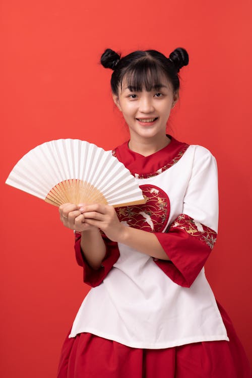 Girl in Traditional Clothes Holding a Hand Fan
