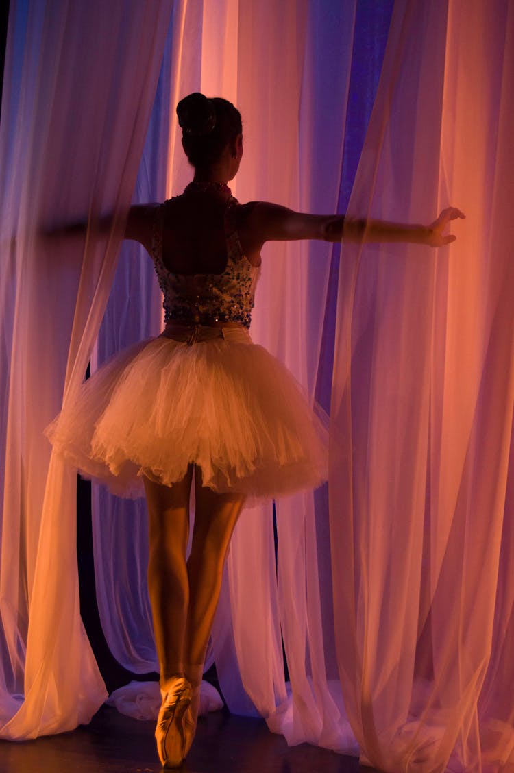 Woman In Tutu Dress Dancing Near Curtain