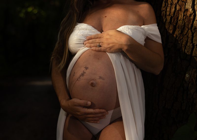 A serene maternity portrait emphasizing the beauty and anticipation of pregnancy in a natural setting.