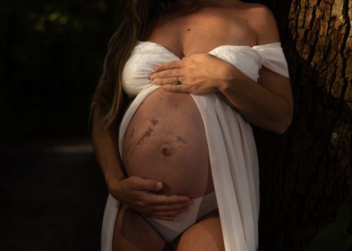 Free A serene maternity portrait emphasizing the beauty and anticipation of pregnancy in a natural setting. Stock Photo