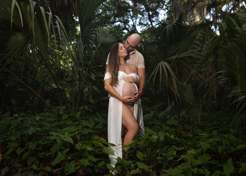 Free Pregnant couple embraces in a serene forest, celebrating their upcoming addition. Stock Photo