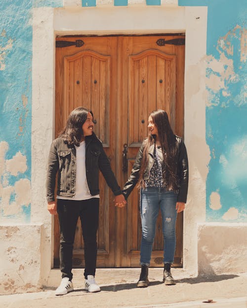Couple Standing in Front of Brown Wooden Door