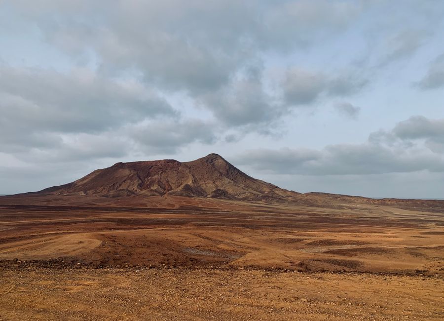 Barren land with dramatic mountain under cloudy sky in Sal, Cape Verde.