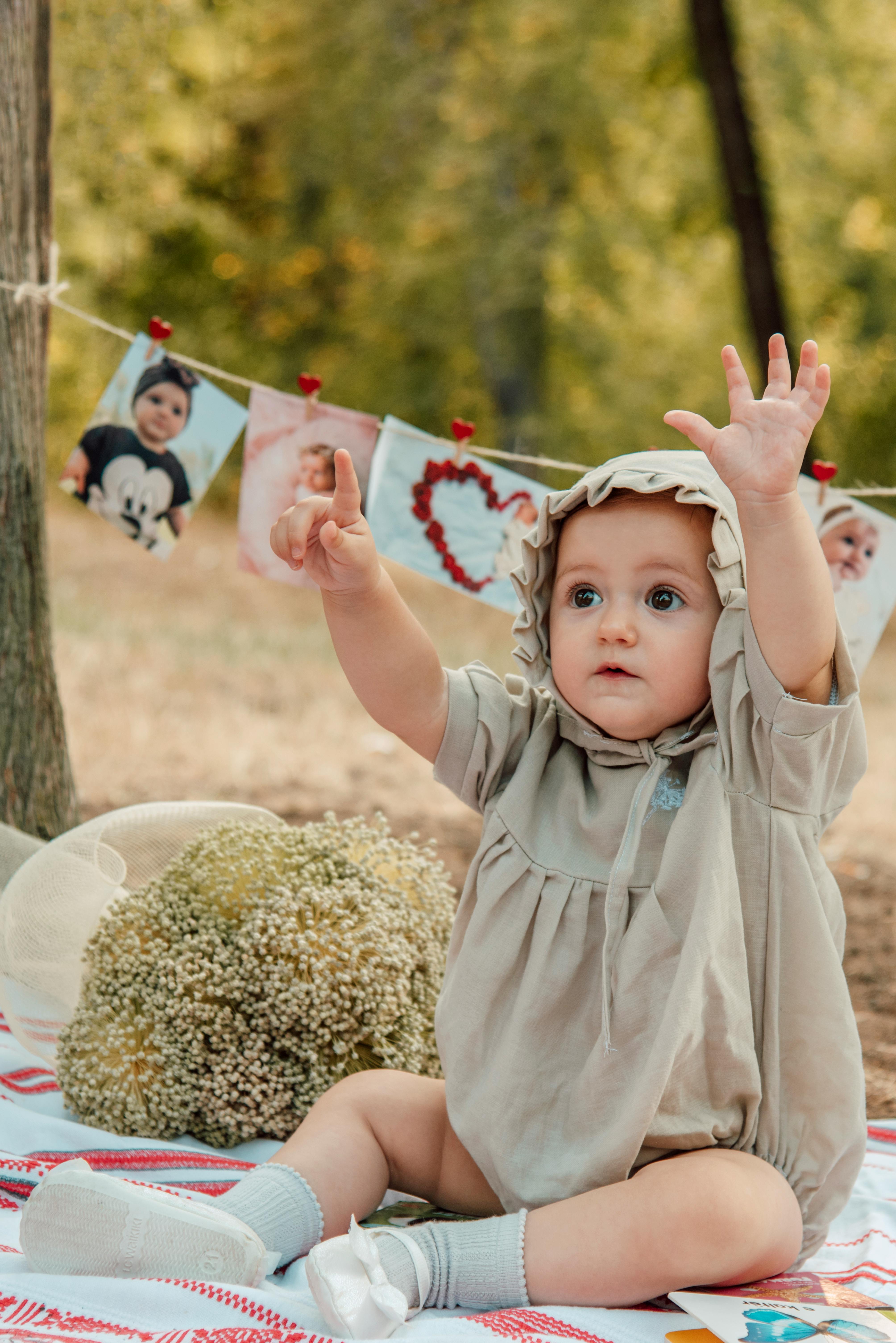 Baby in Brown Onesie Sitting Red and Blue Blanket · Free Stock Photo