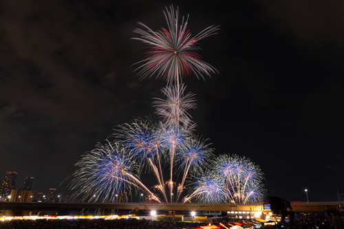 Free A breathtaking fireworks show illuminates the night sky over a city, showcasing vibrant colors against a dark backdrop. Stock Photo