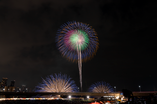 Free Colorful fireworks light up the night sky over an urban skyline, celebrating a festive event. Stock Photo