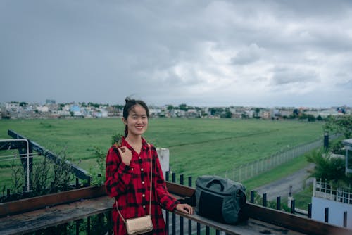 Cute asian girl with long hair on the windy balcony