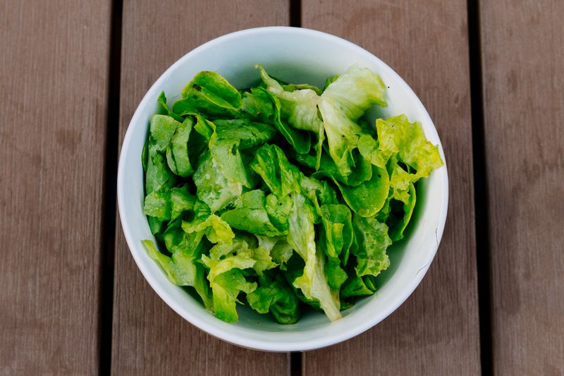 Leaf salad in a stoneware bowl on a timber table. Photo by Kai Pilger on Pexels