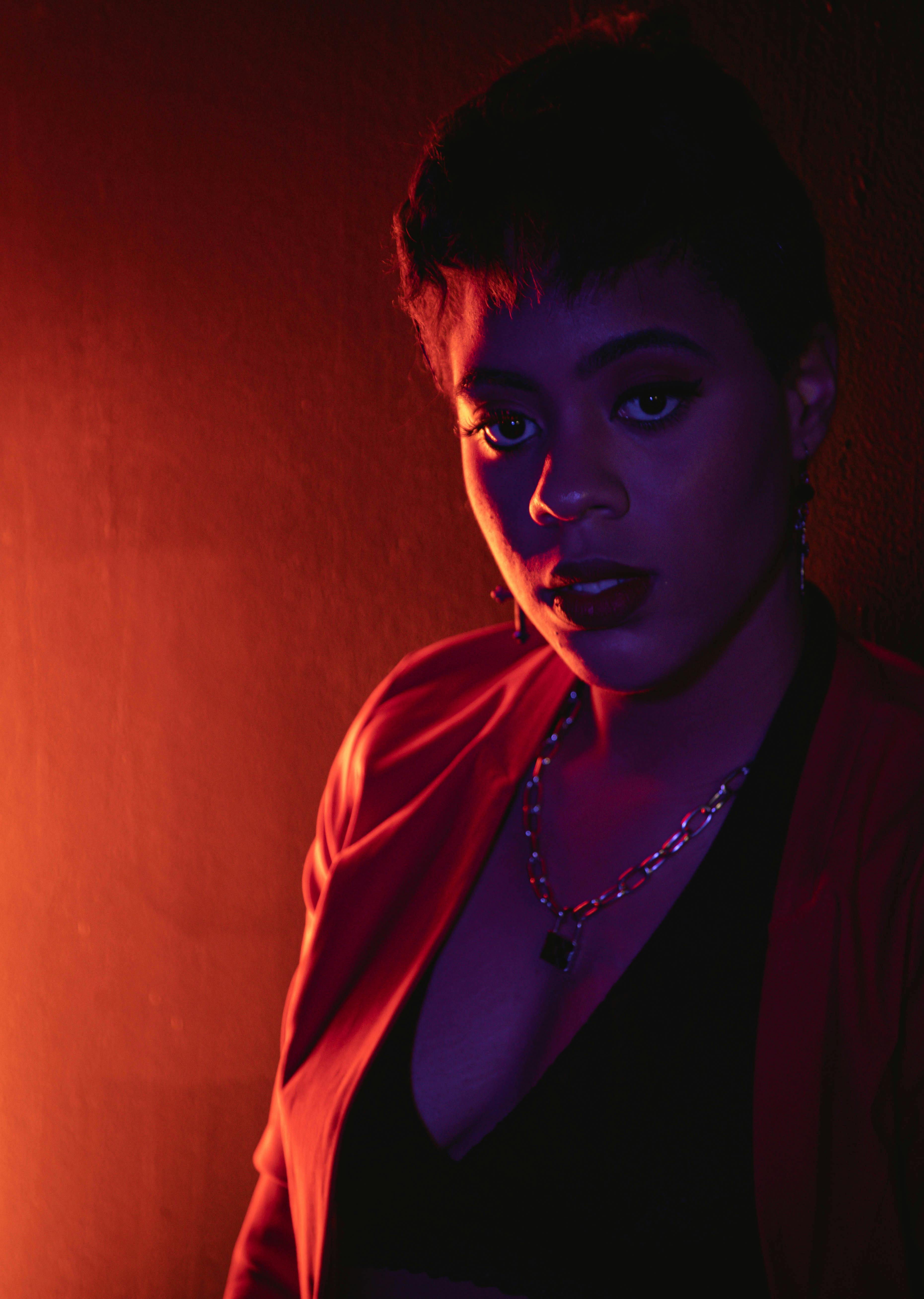 Striking portrait of a woman in red and ultraviolet lighting, creating a moody atmosphere.