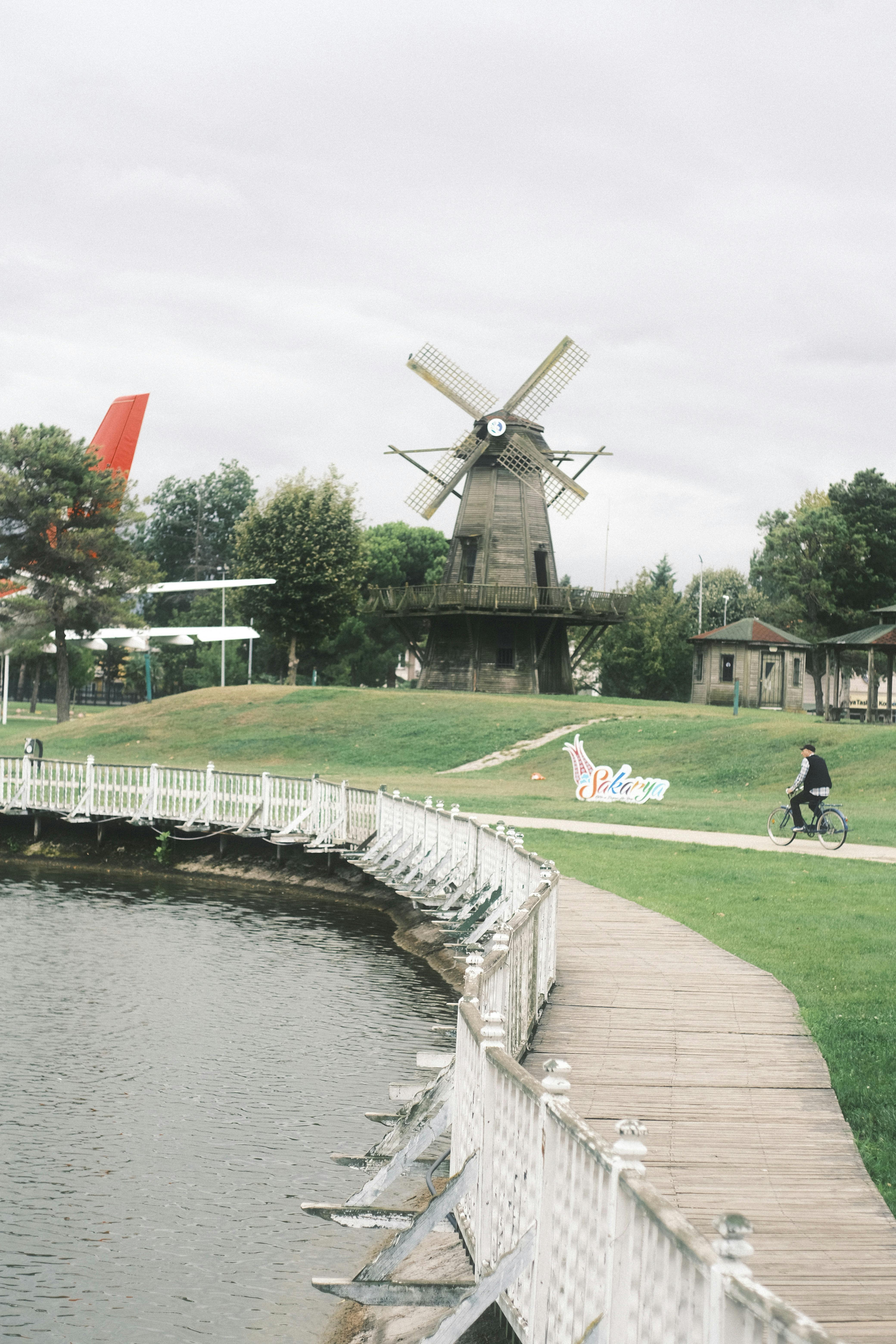 Idyllic scene with a windmill near a waterfront boardwalk, creating a picturesque landscape.