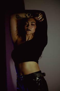 Dark, artistic portrait of a woman posing with confidence in modern fashion.