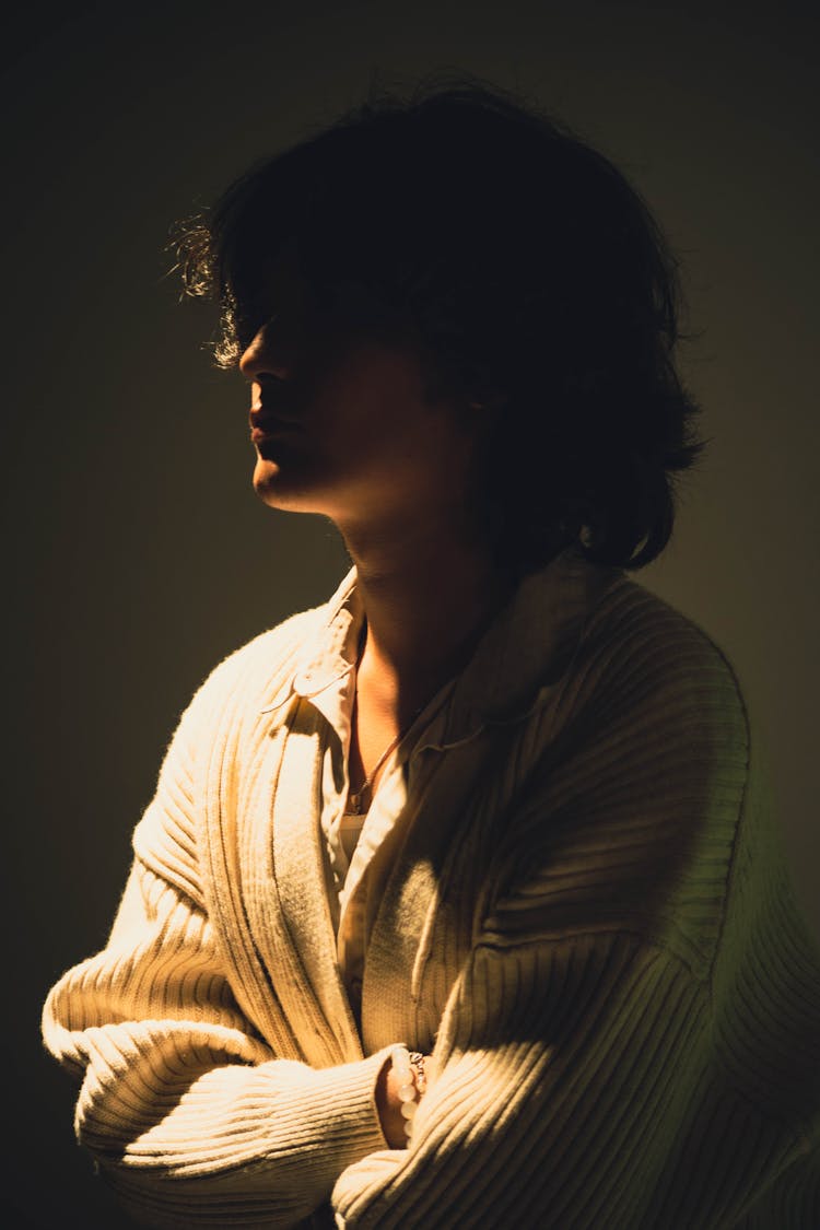 Woman In Shadow Posing On Studio Background