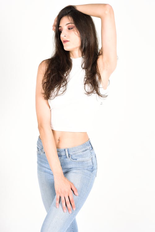 A Woman Wearing White Crop Top and Denim Jeans