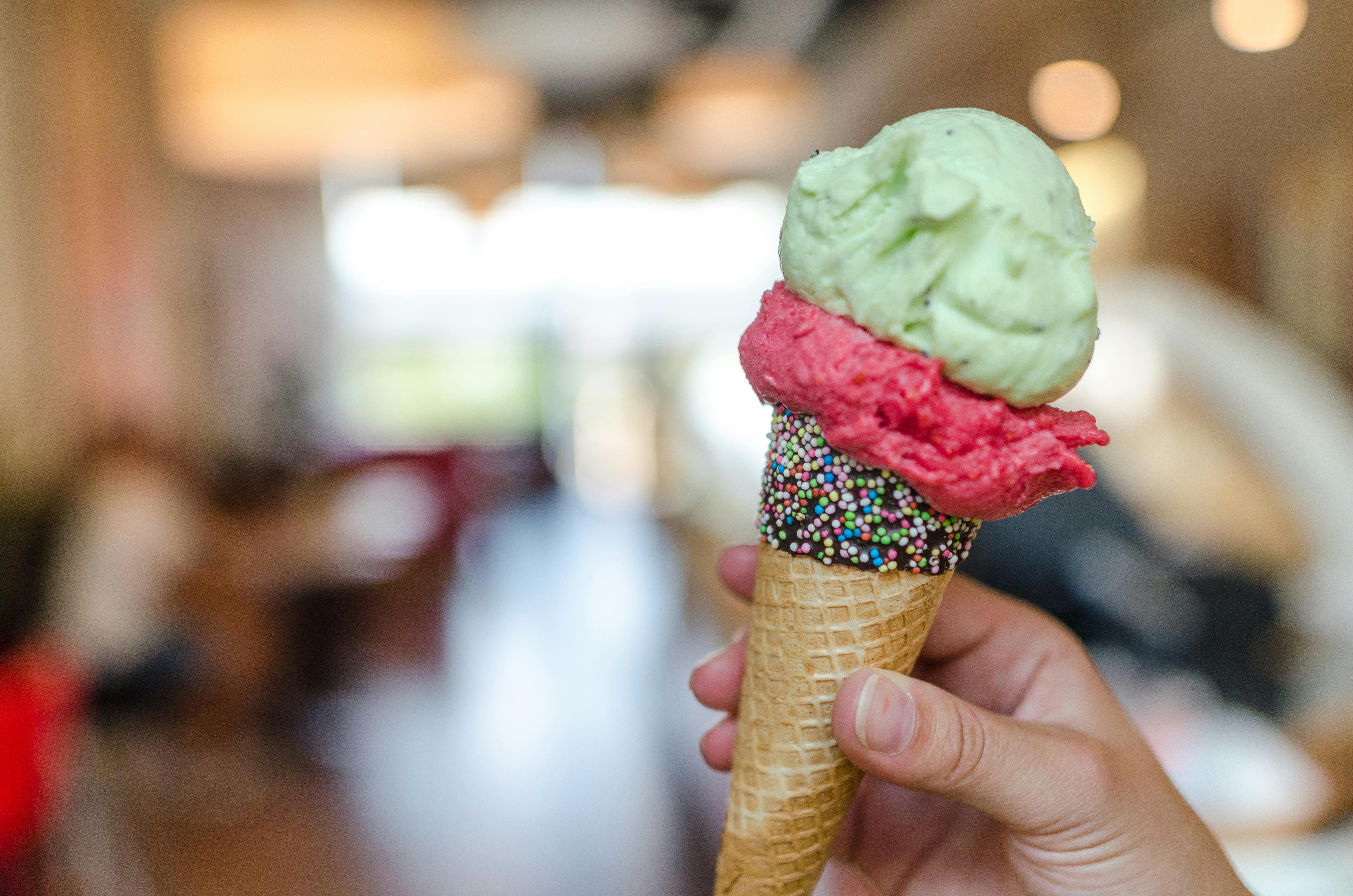 Close up photo of person holding assorted flavor ice cream on cones