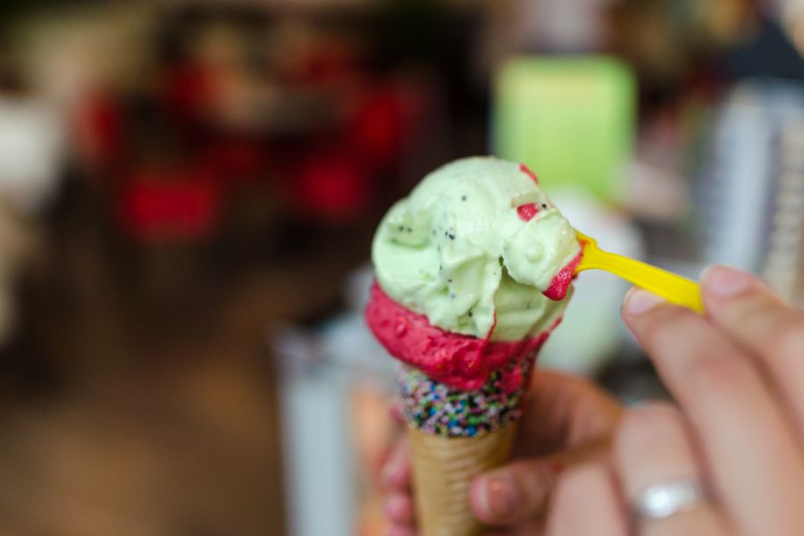 Close-up of a colorful ice cream cone with sprinkles being eaten.