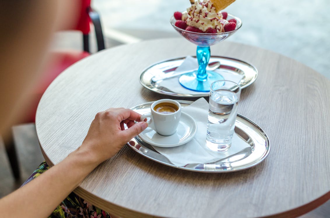 Kahverengi Sıvı Ile Dolu Beyaz çay Fincanı Tutarken Oturan Kişi