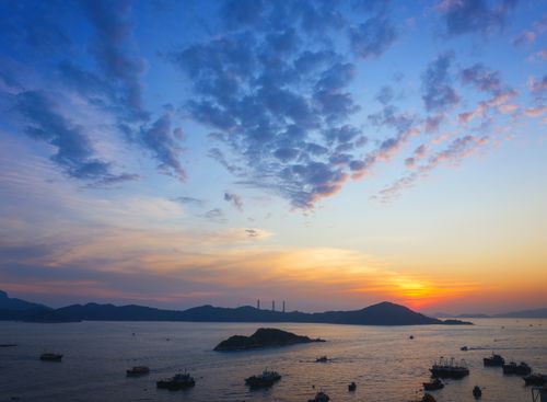 Free A captivating aerial view of a sunset over Hong Kong harbor with boats and islands. Stock Photo
