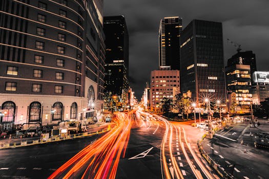 This stunning long exposure captures city nightlife with vibrant light trails and towering skyscrapers.