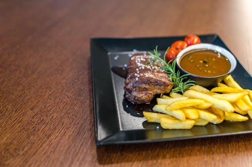Free Grilled Beef With Fries and Sauce on Black Ceramic Plate Stock Photo
