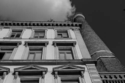 Grayscale Photo of Concrete Building under White Clouds