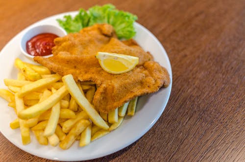 Aardappelfrietjes Met Gebakken Vlees En Rode Saus Op Ronde Witte Keramische Plaat