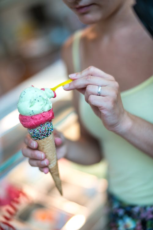 無料 コーンでアイスクリームを保持している女性の選択的な焦点写真 写真素材