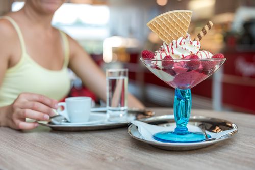 Free Appetizing berry ice cream sundae with waffle cone, served with coffee in a modern cafe. Stock Photo