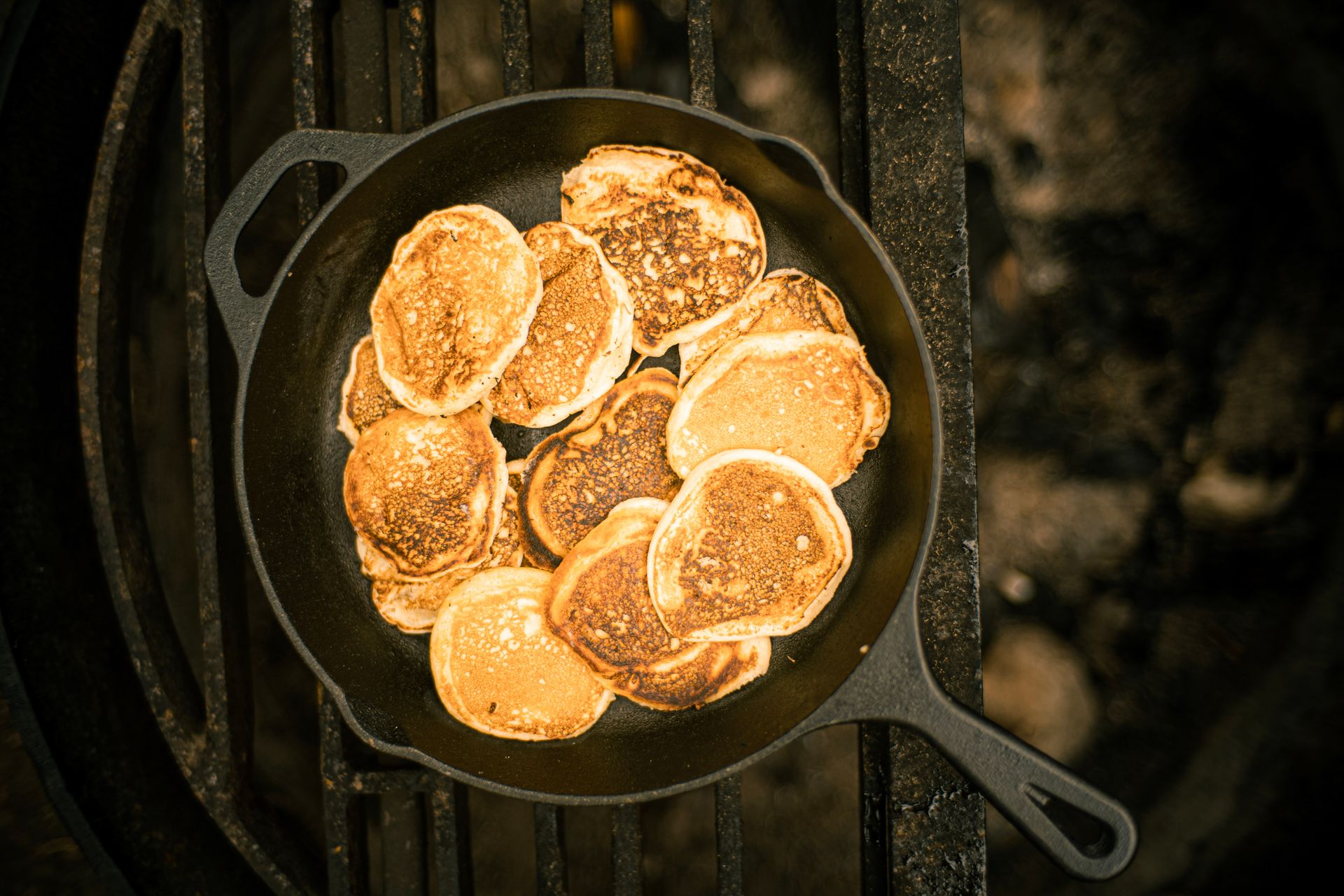 A delicious stack of golden pancakes cooked in a cast iron skillet, photographed from above.