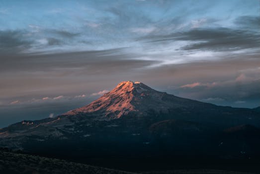 Breathtaking view of a mountain top at sunrise with dramatic skies in a natural landscape.