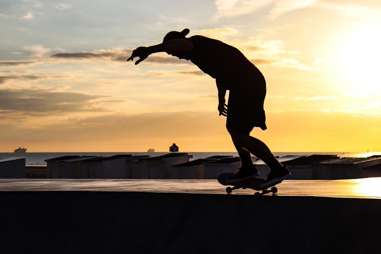 Silhouette Of A Skateboarder During Sunset