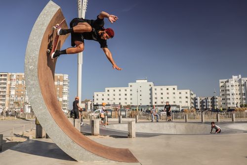Free Skateboarder performs impressive tricks at Calais Skatepark. Urban skateboarding vibe captured on a sunny day. Stock Photo