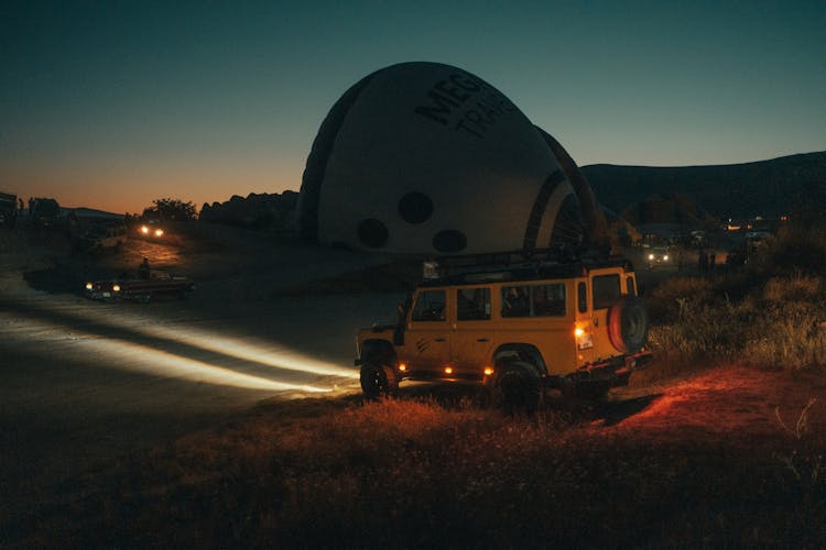 A Wrangler Jeep Parked On A Green Field During Night Time