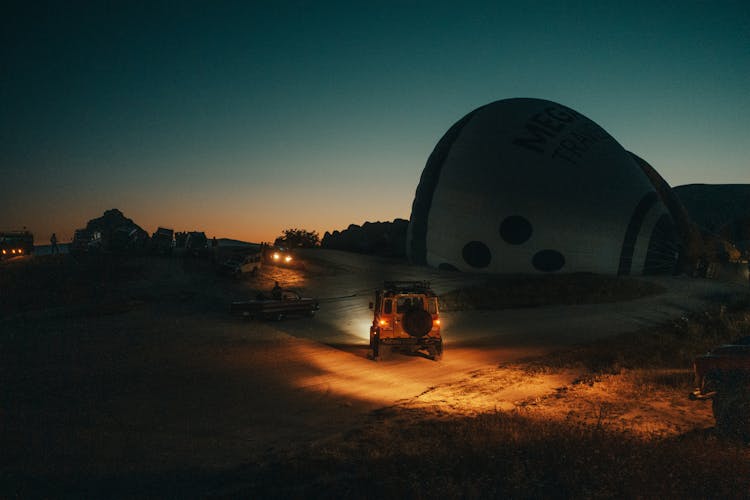 Cars In Nature Near Hot Air Balloons At Night